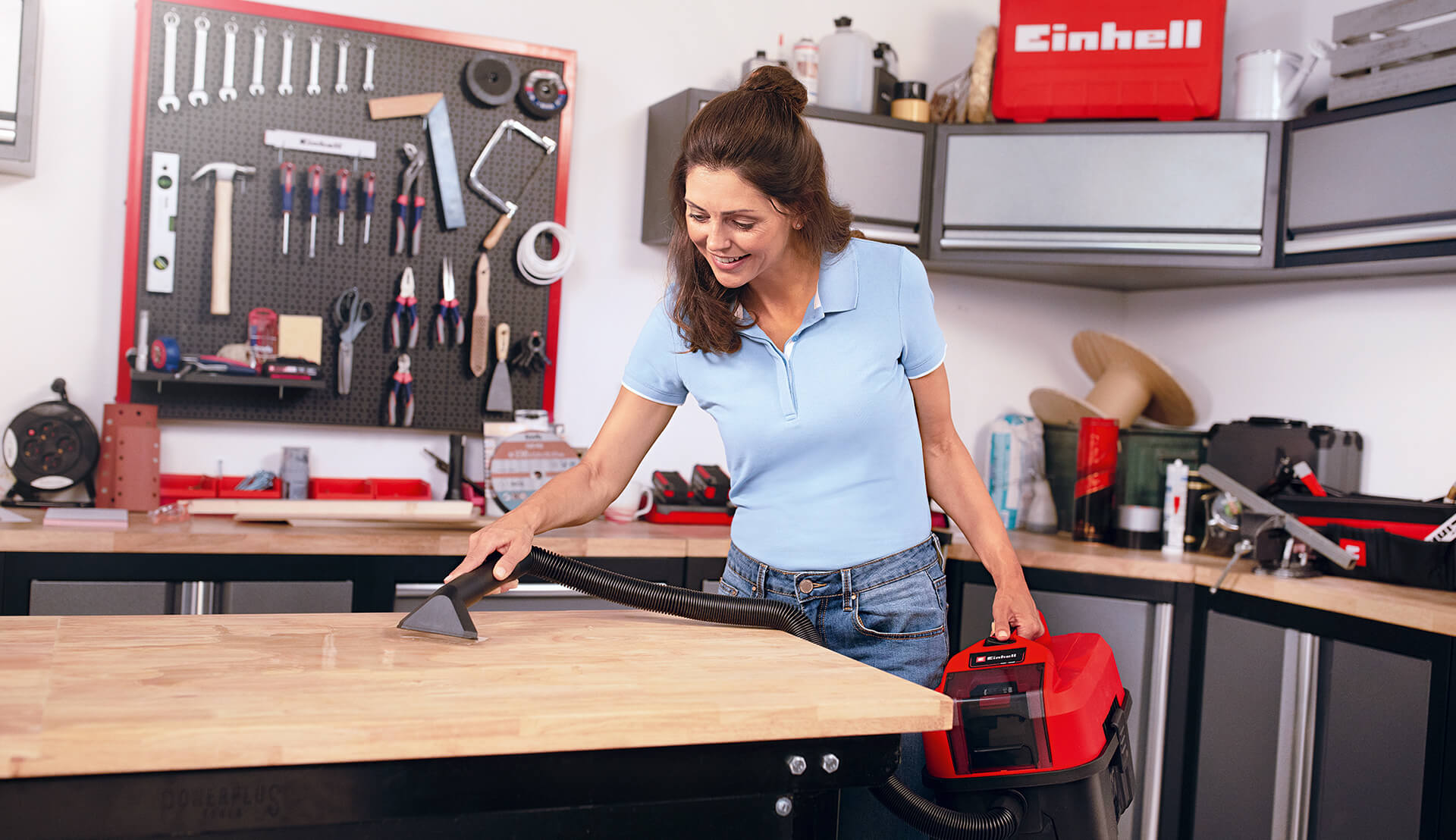 woman cleaning the workshop and sucking up water with a cordless wet / dry vacuum cleaner